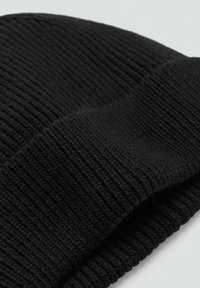Cappello berretto in maglia nera con una texture a coste, caratterizzato da un risvolto piegato. Realizzato in filato morbido, presenta un design senza cuciture.