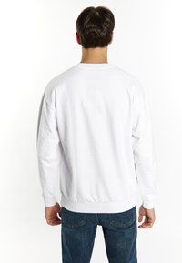 Hvid bomulds sweatshirt med rund halsudskæring, ribbede manchetter og kant. Fittet form ved taljen, glat tekstur, ingen synlig mærkning.