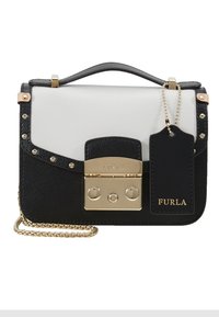 Borsa a mano in pelle bianca e nera con finiture dorate, manico superiore, tracolla a catena, borchie decorative e targhetta rettangolare con il logo del marchio.