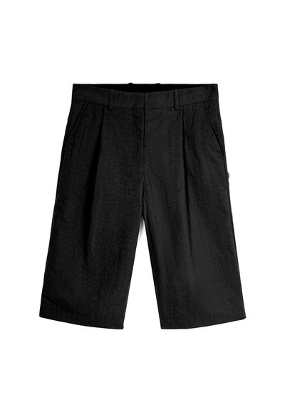 Pantalones cortos negros de tela texturizada, con un frente plano, dos bolsillos laterales y un ajuste relajado. Sin hardware visible ni patrones.