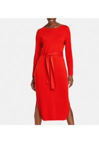 Robe longue rouge à manches longues avec une silhouette ajustée, col rond, ceinture à la taille et fentes sur les côtés, réalisée dans un tissu doux et texturé.