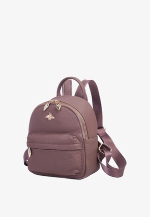 Mały lawendowy skórzany plecak z przednią kieszenią na zamek, złotym emblematem pszczoły, podwójnymi zamkami oraz regulowanymi paskami.