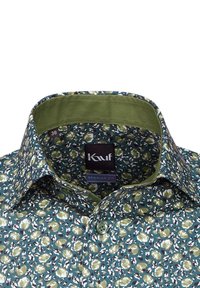 Camicia a fantasia floreale in verde scuro e teal, con colletto strutturato e una fodera interna verde chiaro a contrasto, chiusura con bottoni.