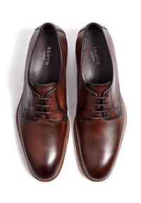 Braune Lederschuhe mit strukturiertem Design, einer glatten Zehenpartie, runden Schnürsenkeln und einer hellbraunen Sohle. Logo innen sichtbar.