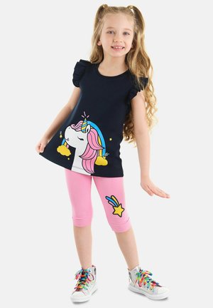 T-shirt navy con maniche a balze, con una grafica di un unicorno; abbinato a leggings a tre quarti rosa decorati con una stella. Sneakers argentate completano l'outfit.