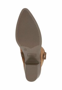 Botín de ante marrón con suela de goma texturizada, cuenta con un tacón bajo y un zipper lateral. La suela tiene un patrón de diamantes para mayor agarre.
