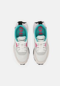 White athletic sneakers with a mix of textile and suede, featuring turquoise and pink accents, black heel tab, and white laces.