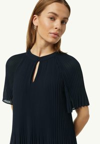 Marineblaues, plissiertes Kleid mit einem Schlüssellochausschnitt, kurzen, schwingenden Ärmeln und weichem Material. Verfügt über vertikale Falten und gewellte Ärmelabschlüsse.