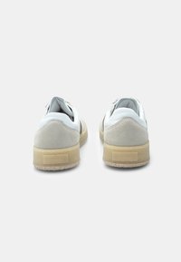 Sneakers bianchi in pelle con dettagli in suede, punta rotonda, collarino imbottito e suola in gomma. Design semplice con una combinazione di colori neutra.