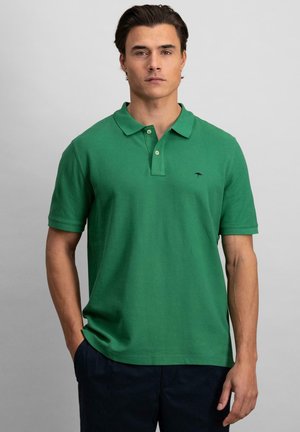 Zelená polo košeľa vyrobená z bavlny, s klasickým golierom, krátkymi rukávmi a malým vyšitým logom na ľavej hrudi.