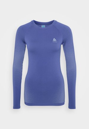 T-shirt de sport à manches longues en tissu violet uni avec des accents en maille texturée. Présente un col rond et un logo discret sur la poitrine.