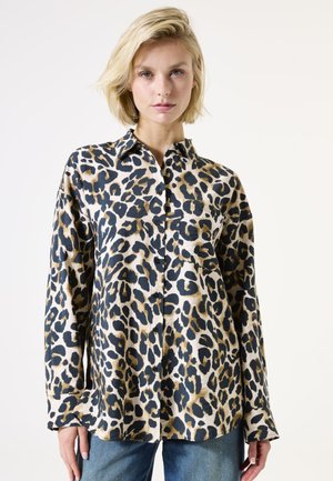 Chemise à boutons imprimée léopard avec un schéma de couleurs beige et noir, dotée de manches longues et d'un col classique. Texture douce.