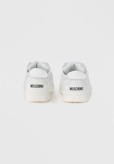 Λευκά αθλητικά παπούτσια με λείο δερμάτινο φινίρισμα, με παχιά  λευκή σόλα και ανάγλυφη επιγραφή "MOSCHINO" στην ταμπέλα της φτέρνας.
