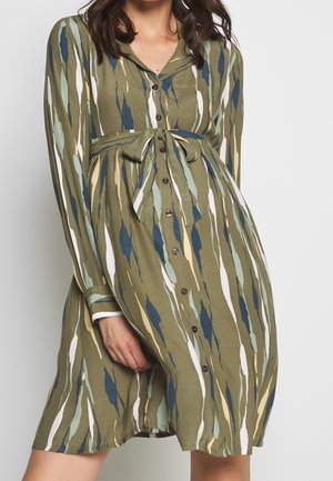 Groen jurkje met een patroon van verticale strepen in blauw, wit en beige. Lange mouwen, knoopsluiting aan de voorkant en een ceintuur in de taille.