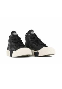 Svarte høye sneakers med en teksturert svart overdel, hvit gummitåhette og mønstret hvit såle. Har svarte snører og merkevaren på tungen.