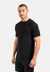 Camiseta negra de manga corta con cuello redondo, fabricada en un tejido suave. Presenta un diseño ajustado y un ligero estiramiento para mayor comodidad.