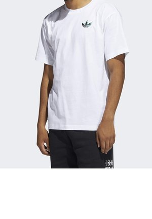 Homme portant un t-shirt blanc à manches courtes avec un petit logo coloré sur la poitrine gauche et un short noir avec un graphisme blanc sur la jambe.