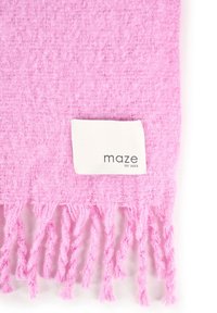 Zacht roze geweven stof met franjes aan de randen en een wit label met de tekst "maze EST 2003" bevestigd bij de onderkant in het midden.