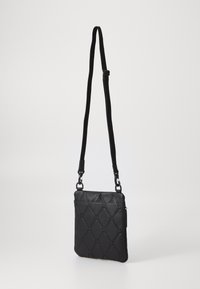 Schwarze Ledertasche mit gestepptem Muster, verstellbarem schwarzen Tragegurt, seitlicher Reißverschlusstasche, rechteckiger Form und glatter Textur.