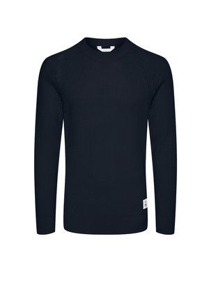 Tamno plavi rebrasti pleteni pulover s dugim rukavima, okruglim izrezom i malom etiketom na donjem lijevom dijelu. Teksturirana struktura tkanine.