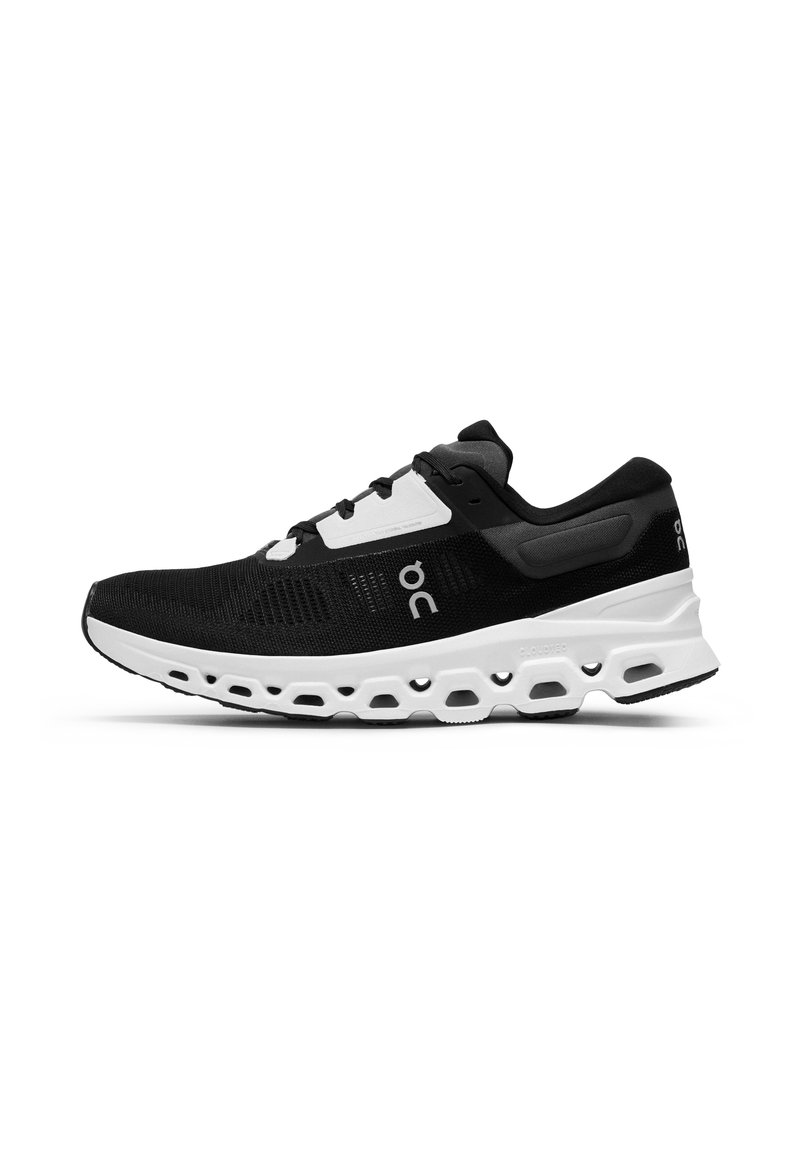 Zapatilla deportiva en blanco y negro con parte superior de malla transpirable, mediasuela acolchada y suela con patrón para tracción.