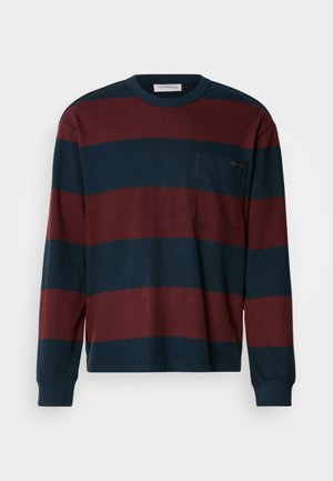 Langermet stripete skjorte i marineblått og burgunder, med rund hals og brystlomme med en diskret logodetalj. Laget av bomull.