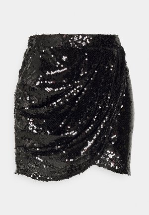 Jupe mini en sequins noirs avec un design drapé, présentant une texture lisse et une surface brillante, renforçant l'attrait visuel par la réflexion de la lumière.