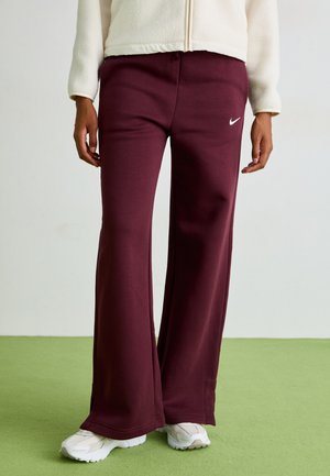 Bordeaux kleurige sweatpants van zachte stof, met een ontspannen pasvorm, subtiele zijsplitten en een klein wit Nike-logo op de linker bovenbeen.