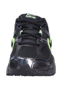 Zapatillas deportivas negras con parte superior de malla, acentos brillantes y detalles en verde neón. Diseñadas con una lengüeta acolchada y suela texturizada.