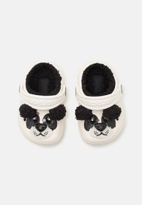 Sabots blancs en caoutchouc avec un design de visage de panda. Texture noire douce pour les oreilles, yeux surdimensionnés et nez. Équipés d'une sangle réglable pour un ajustement sûr.