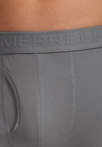 Graue Herrenunterwäsche mit einem strukturierten Bund, auf dem der Markenname "MERRELL" steht. Der Stoff ist glatt und hat eine enganliegende Passform.