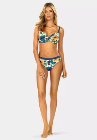 Kostium kąpielowy w kwiatowy wzór z miękkiego materiału, z wielokolorowymi kwiatami na jasnym tle. Granatowe akcenty na ramiączkach i talii.