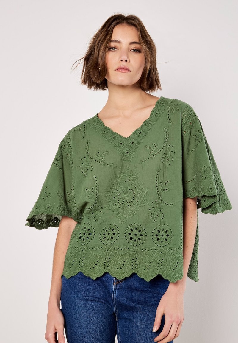 Grüne, bestickte Bluse mit V-Ausschnitt, gewelltem Saum und kurzen Ärmeln. Verfügt über florale Muster und Lochstickerei überall.