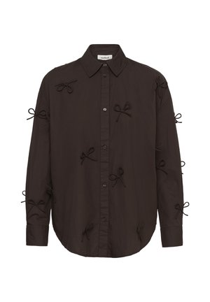 Chemise brune àboutons en tissu, avec un ourlet arrondi, des manches longues et des nœuds en tissu décoratifs sur les manches et à l'avant.