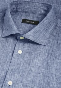 Camicia in lino blu con colletto strutturato, caratterizzata da una texture di sottili linee orizzontali. Include tre bottoni bianchi sul davanti.