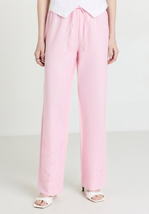 Pantaloni ampi di un rosa chiaro, con vita regolabile tramite coulisse. Presentano ricami floreali all'orlo. Realizzati in un tessuto morbido e leggero.