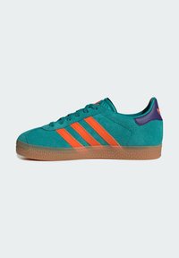 Teal suede sneaker with vibrant orange three stripes and purple heel accent. Features a textured gum rubber sole for grip.