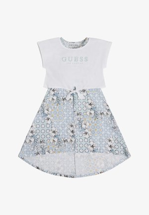 Top in cotone bianco con il logo "GUESS LOS ANGELES". Gonna blu a fantasia floreale con bordi bianchi e dettagli con nodo in vita.