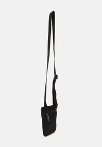 Borsa a tracolla nera con una texture di tessuto liscia, una sottile tracolla regolabile e un compartimento con zip nella parte anteriore. Design minimalista.