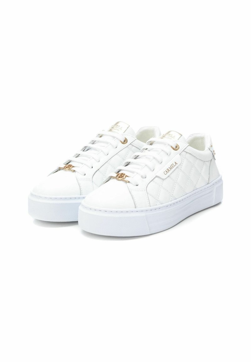 Baskets en cuir blanc avec un motif matelassé, accents en matériel doré, semelles en caoutchouc blanc plat et un logo de marque bien visible sur la languette.