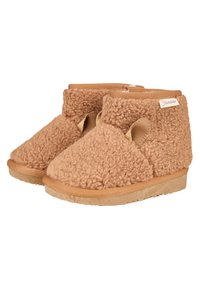 Braune, flauschige Hausschuhe mit einem weichen Textil-Obermaterial, offenen Seiten und einer strukturierten Sohle in einem leichten Design. Mit einem kleinen Markenetikett.