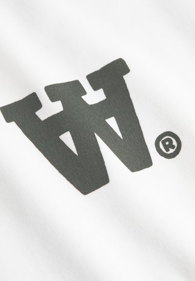 Tessuto bianco con un grande logo "W" grigio scuro con simbolo di marchio registrato. La texture appare liscia e elastica.