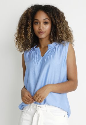 Light blue sleeveless top with a V-neck and gathered neckline, made of soft fabric. Paired with white high-waisted pants.