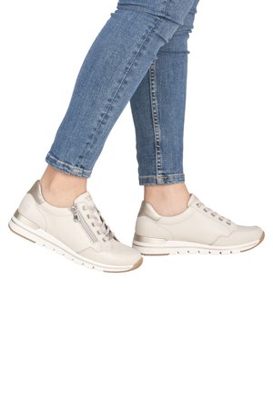 Light beige leather sneakers with a textured finish, featuring a lace-up front, zip closure, and a cushioned white sole with a tan accent.