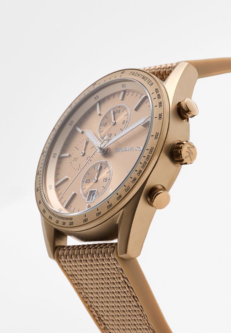 Montre chronographe en ton or avec lunette tachymétrique, trois sous-dials, fenêtre de date et bracelet en tissu beige tissé.
