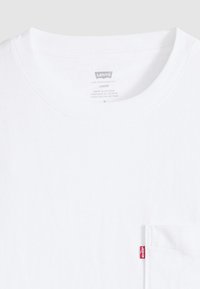 Λευκό βαμβακερό t-shirt με άνετη εφαρμογή, που διαθέτει τσέπη στην αριστερή πλευρά και μικρή κόκκινη ετικέτα με το λογότυπο Levi's στο τελείωμα.