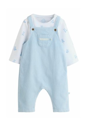 Hellblaue Cord-Overall mit Schulterträgern und goldenen Verschlüssen, ausgestattet mit einer Tasche. Darunter befindet sich ein weißes Langarmshirt mit Bärenmustern.