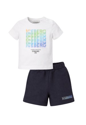 Camicia bianca a maniche corte con testo colorato ripetuto "ICEBERG" e pantaloncini neri con piccolo testo "ICEBERG" sulla gamba sinistra, vita elastica.