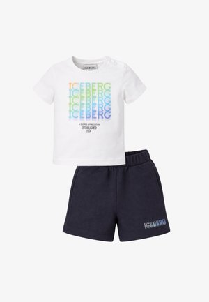 Camicia bianca a maniche corte con testo colorato ripetuto "ICEBERG" e pantaloncini neri con piccolo testo "ICEBERG" sulla gamba sinistra, vita elastica.