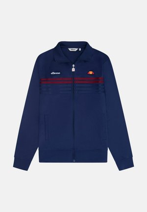 Marineblaue Zip-Jacke aus glattem Material mit hohem Kragen, zwei seitlichen Taschen, roten und blauen Streifen auf der Vorderseite und Logodetails.